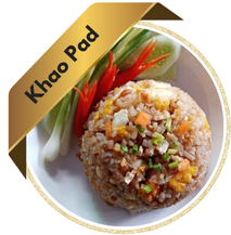 A plate of Khao Pad (Thai fried rice) featuring stir-fried rice with vegetables, egg, and meat or shrimp, garnished with lime and cucumber slices.