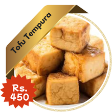 A stack of golden-brown Thai-style tofu tempura cubes, lightly fried and served on a white plate. A gold ribbon label at the top left reads "Tofu Tempura," and a red starburst label at the bottom displays the price as "Rs. 450."